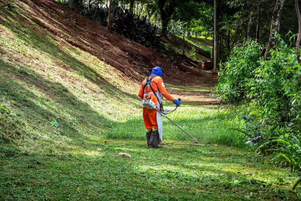 Illustrative photograph of a worker trimming a grassy slope; not a photo of Ironwood’s work